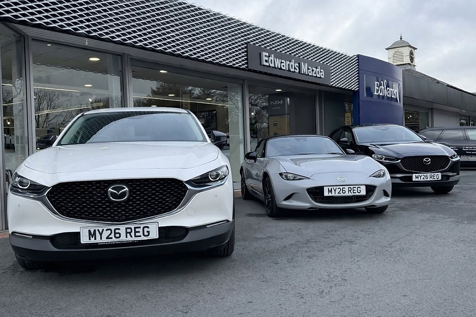Three Mazda vehicles including a white SUV silver sports car and black SUV parked outside