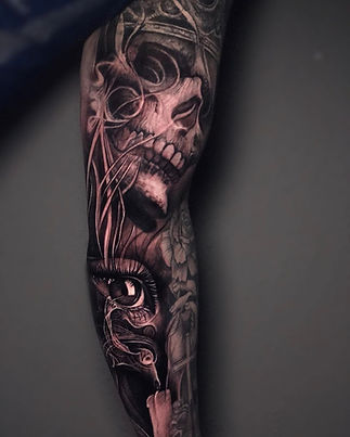 Black and gray tattoo sleeve featuring an intricately detailed skull