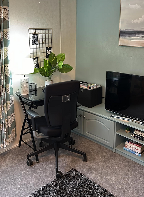 Home office study setup with dark desk office chair and television unit