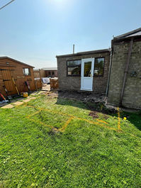 Garden lawn area facing the rear of a residential property during building works