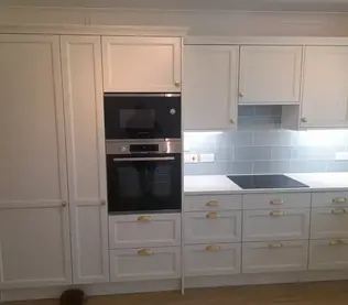 Modern kitchen with white cabinets and brass handles