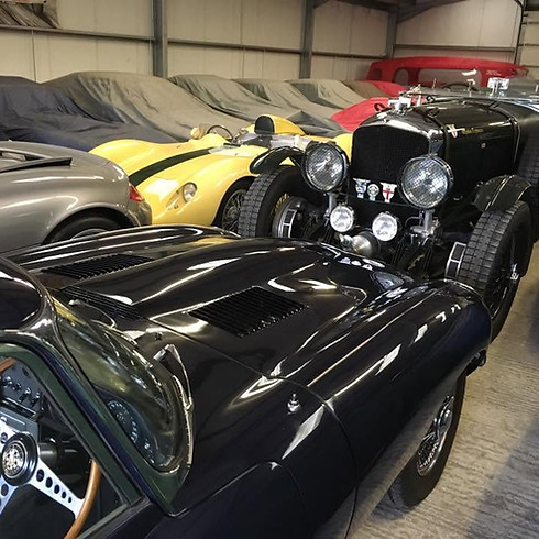 Collection of classic vintage sports cars stored in a warehouse