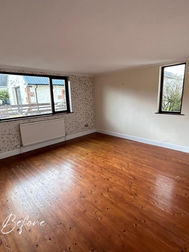 Empty room space before staging showing wood laminate floor and bare walls   