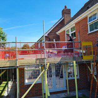 Building work in progress with scaffolding around a new brick home extension
