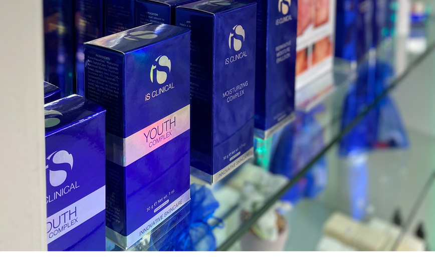 Range of premium iS Clinical skincare products displayed on a glass shelf at HB Therapy