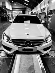 Black and white image of a white Mercedes-Benz in a garage