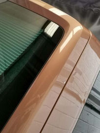 Close up exterior view of sleek tinted side windows on a metallic bronze campervan