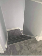 Neat grey carpet fitted along a landing and down a short step