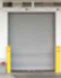 A roller door with two yellow bollards on both sides.