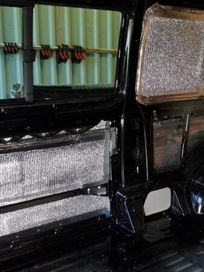 Inside a van conversion showing silver foil insulation applied to the side panels
