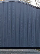 A large blue gate with subtle vertical patterns and a curved top