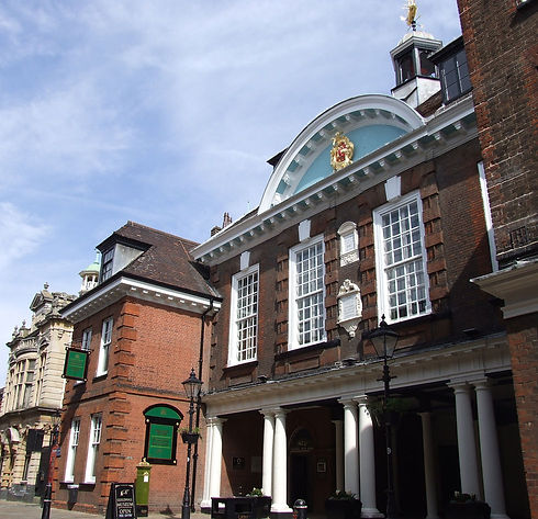 Historic brick building with tall white windows, ornate pediment