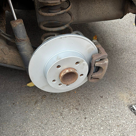A close-up of a car's new brake disc and caliper assembly