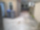 A small, concrete backyard with two gray recycling bins