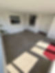 An empty room with grey tiled flooring white walls three white doors windows
