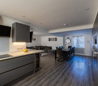 Modern open-plan kitchen and living room with wooden flooring