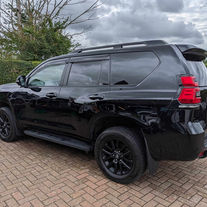 Gloss black Toyota SUV parked on a brick driveway showing clean bodywork and alloy wheels