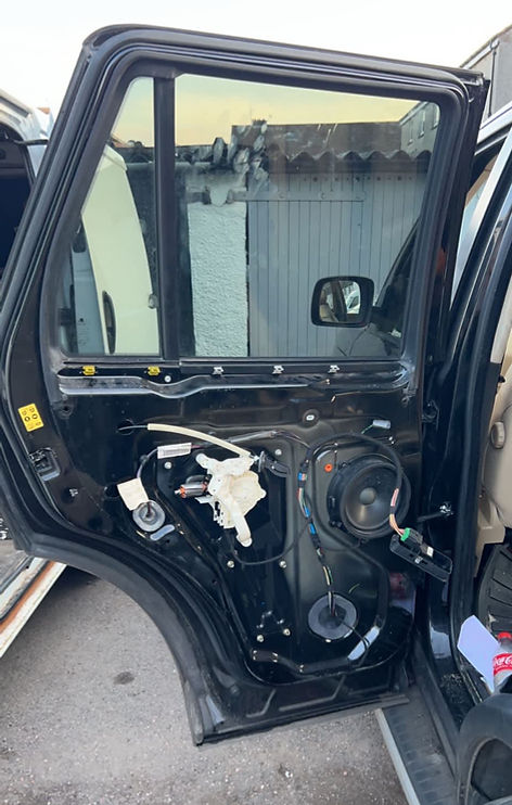 Vehicle rear door removed showing internal door panel mechanisms