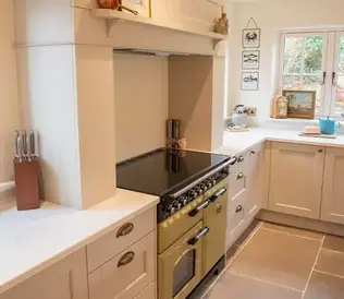 Bright kitchen with cream cabinetry and a vintage-style olive green stove