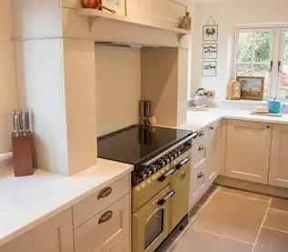 Bright kitchen with cream cabinetry and a vintage-style olive green stove