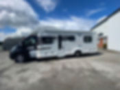 White and black campervan parked outdoors