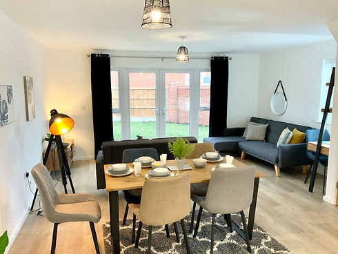 Spacious open plan living and dining area with wooden table and plush sofa   