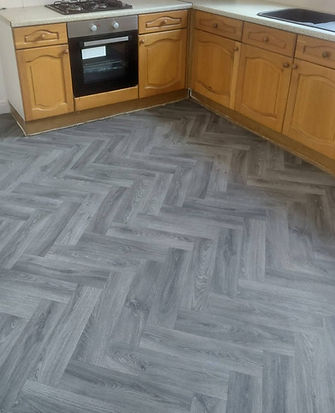 Grey herringbone wood effect flooring in a kitchen
