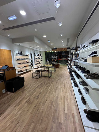 Modern shoe store interior with wooden flooring, bright overhead lighting