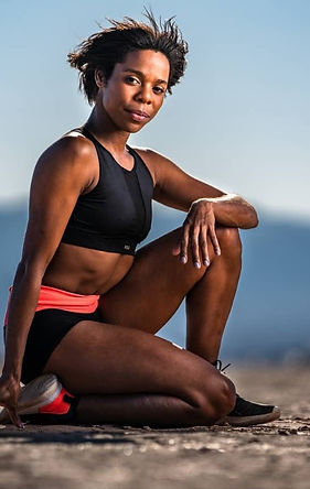 Black Female Fitness Instructor crouched in the desert