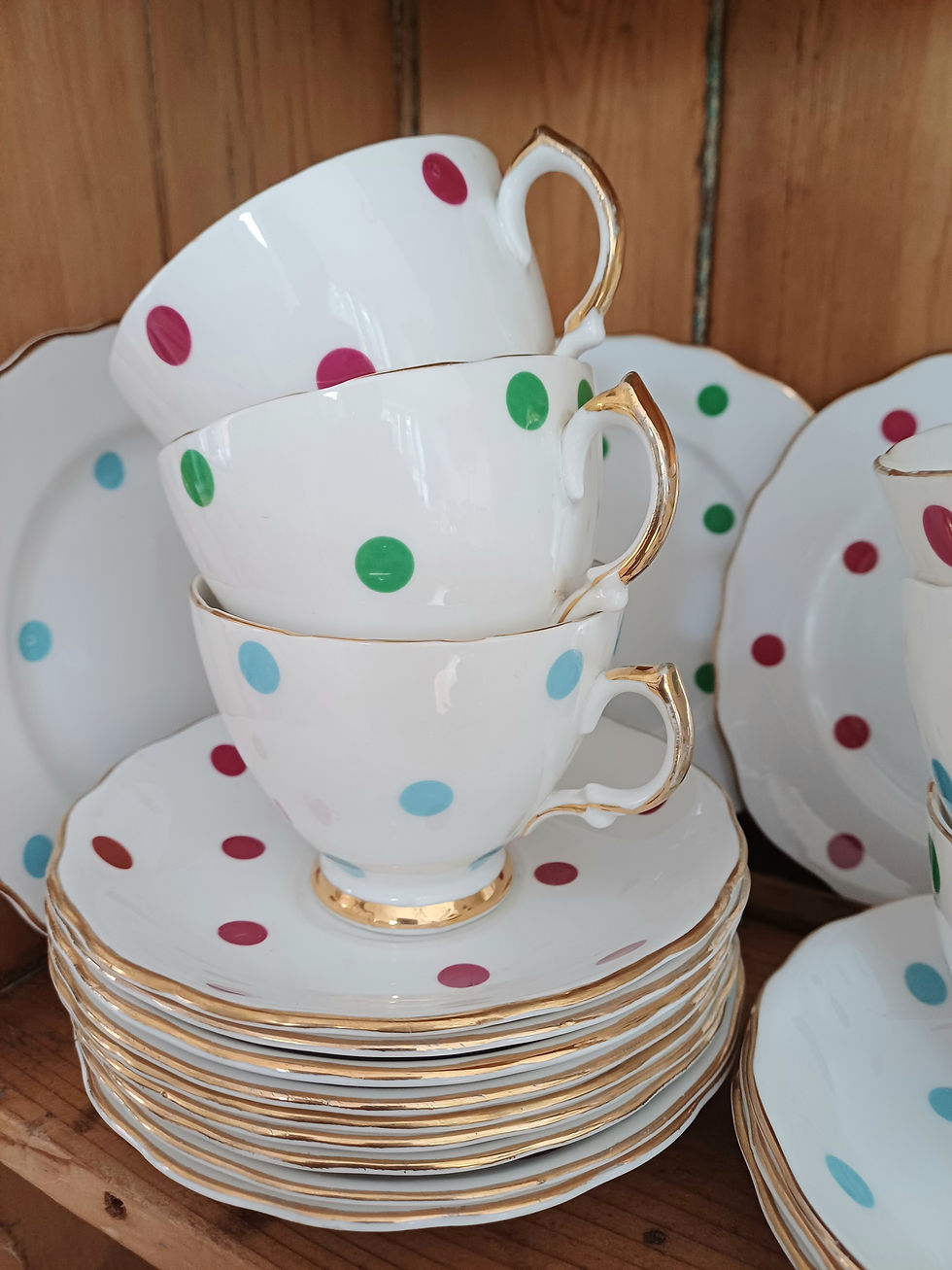 Eye-level view of a vintage china tea set arranged on a rustic wooden table