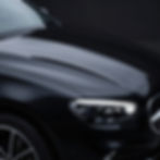 Polished black car hood after professional auto detailing.
