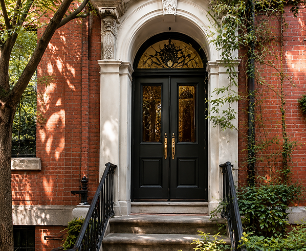 Red-brick townhouse entrance with arched stone surround and black front door