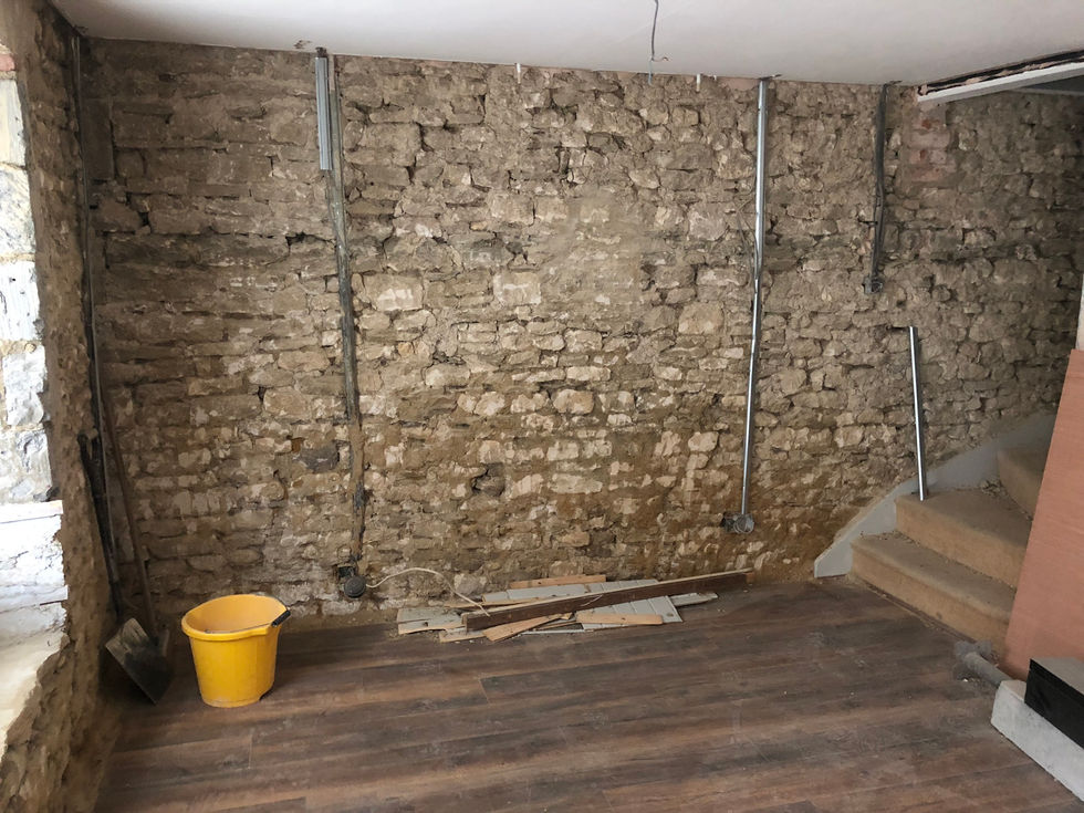 Exposed Cotswold stone walls revealed during a renovation to remove damp-trapping materials.