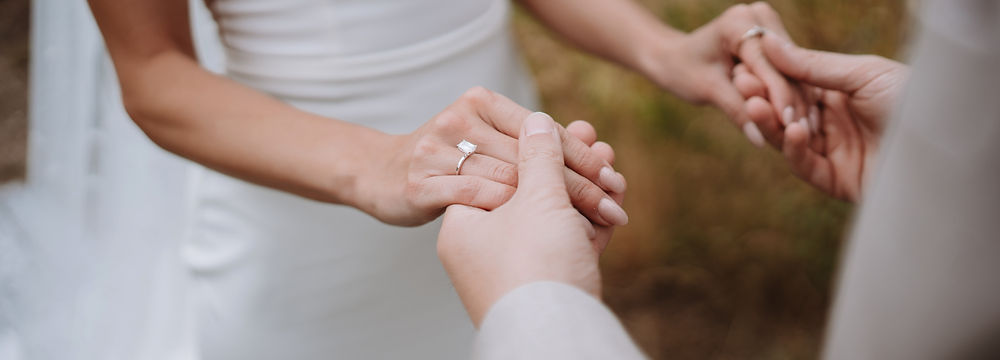 Bride and groom holding hands, showing wedding ring
