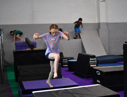 Girl jumping through obstacle course