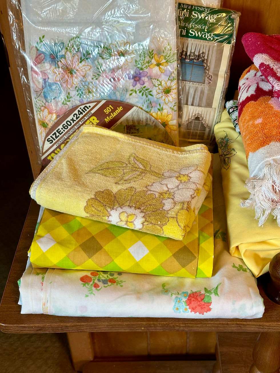 Wooden shelf with yellow and green vintage sheets and other vintage linens