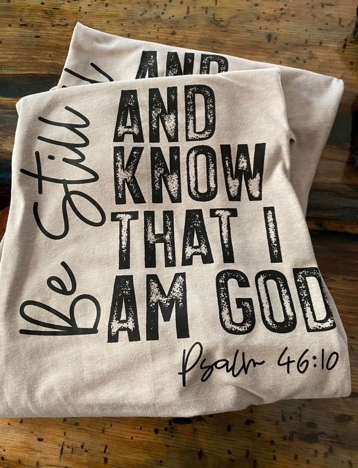Two t-shirts with 'BE STILL AND KNOW THAT I AM GOD Psalm 46:10'
