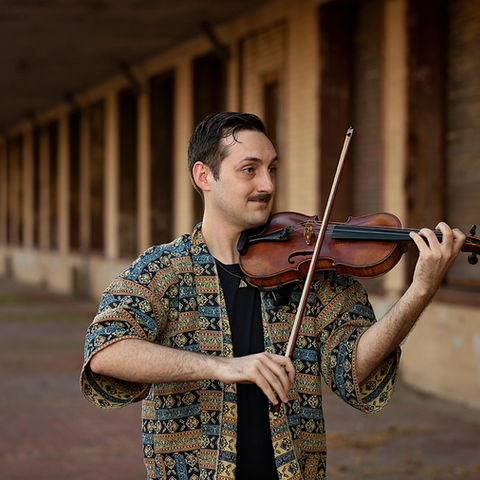 River holding and playing the violin