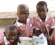 Boy sitting with a book at Circle of Peace School in Uganda