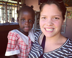 Image of a volunteer holding a student at Circle of Peace School in Uganda