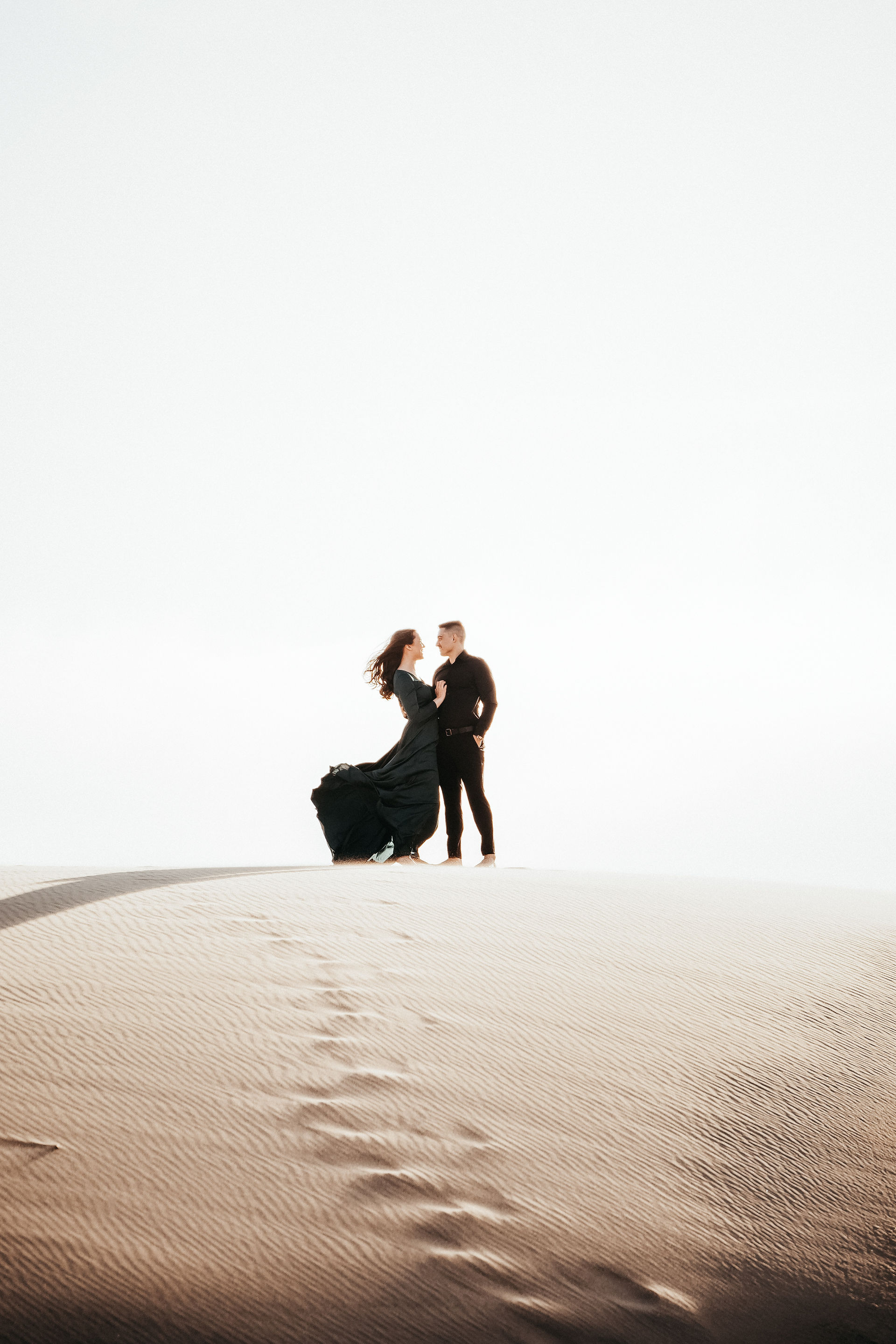 A couple is posing on the sand