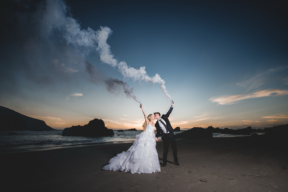 wedding couple kiss with smoke bombs and beautiful landscape view
