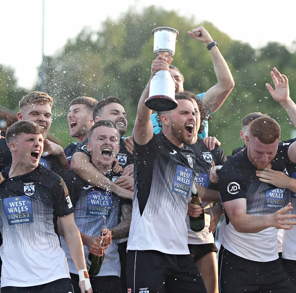 Dylan Rees holds aloft the Play-Off winning trophy that was a mere dream in January. Photo belongs to Sam Eadon/FAW