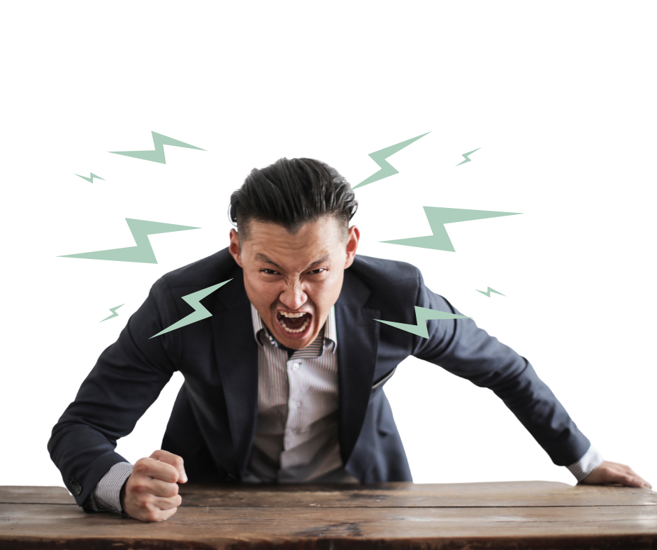A man bashing his fist on the table and with an angry expression on his face.
