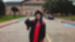 Jess Russi in her black and red graduation gown makes the cougar paw sign, standing in front of the architecture building at UH.