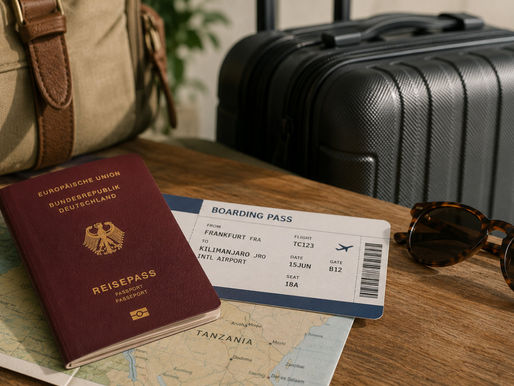 Reisepass, Reiseunterlagen und Koffer als Vorbereitung für die Einreise nach Tansania.