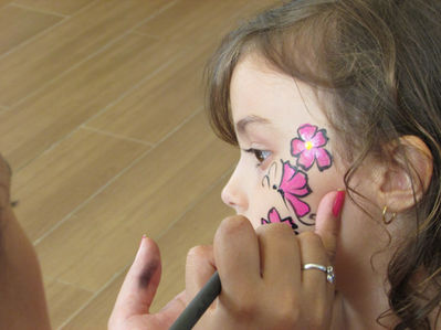 Criança recebe pintura de flor no rosto, EVENTO SOCIAL E FESTA INFANTIL, close-up.
