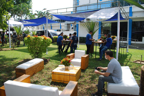 Grupo de pessoas reunidas ao ar livre, cadeiras e mesas; EVENTOS CORPORATIVOS.