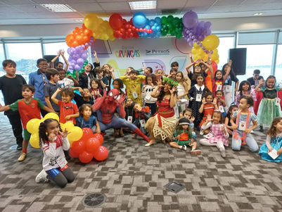 Crianças e adultos em evento com balões coloridos e arco-íris. EVENTO SOCIAL E FESTA INFANTIL.