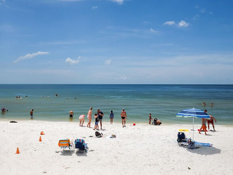 Clam Pass Park beach in Naples Florida with white sand, calm Gulf waters, and visitors enjoying a sunny day